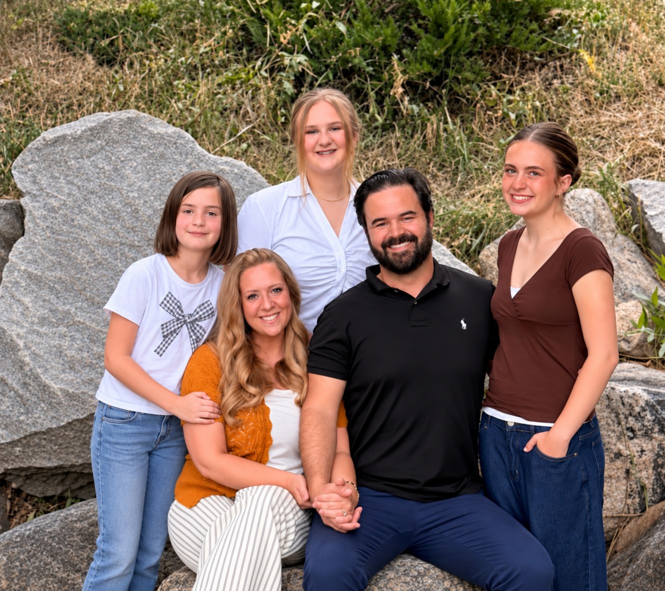 The Gourley family together outdoors among rocks